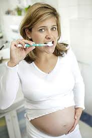 Беременная женщина и зубная щетка