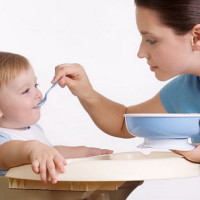 мама кормит ребенка с ложки